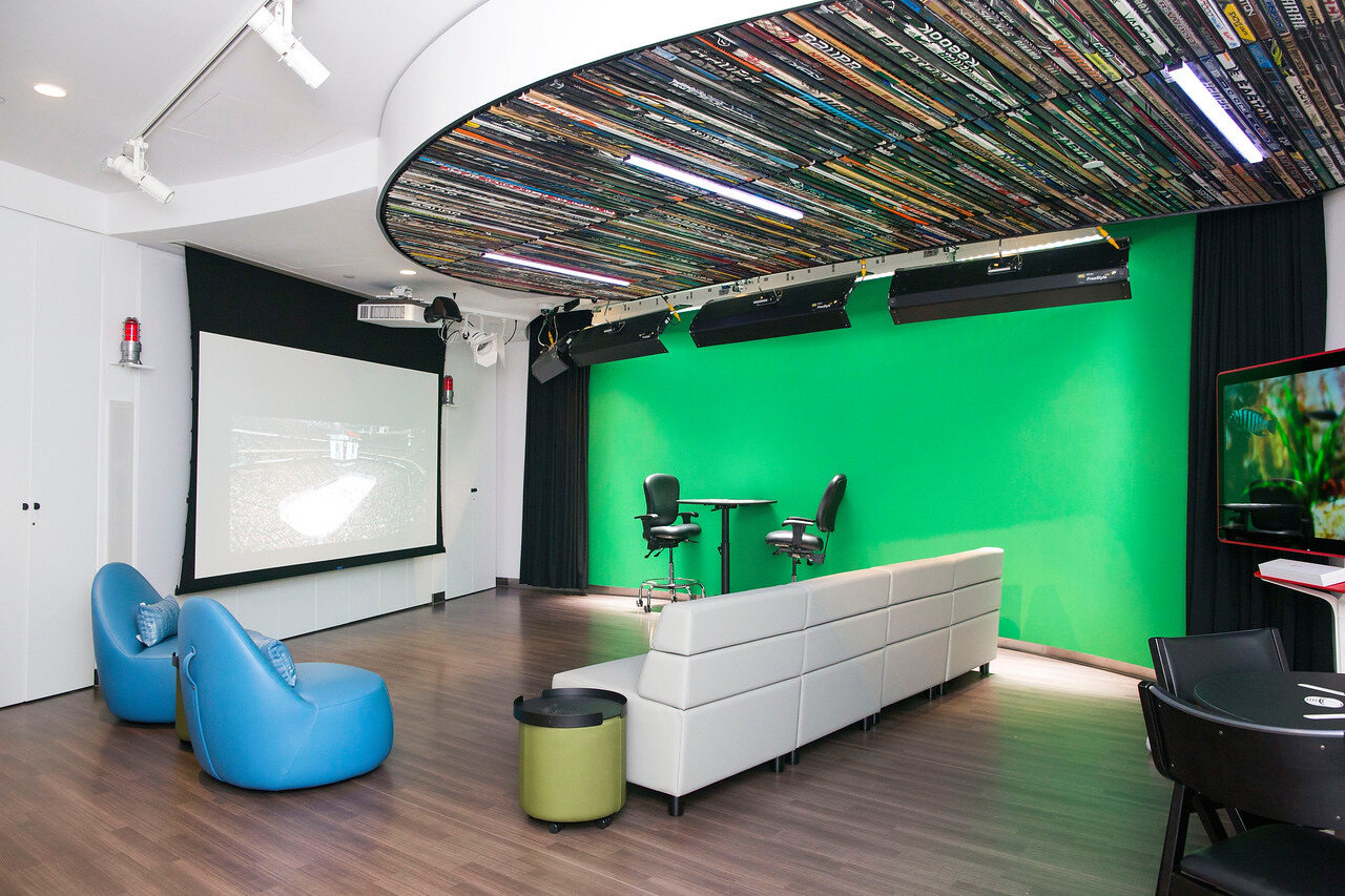 The Zucker Family Broadcast Studio with a hockey stick ceiling, green screen, lounge seating, and projection screen